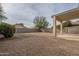 Gravel backyard with covered patio and block wall at 4933 E Meadow Mist Ln, San Tan Valley, AZ 85140