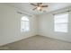 Bright bedroom with ceiling fan and arched window at 4933 E Meadow Mist Ln, San Tan Valley, AZ 85140