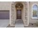 Front entry with stone details and a dark brown door at 4933 E Meadow Mist Ln, San Tan Valley, AZ 85140