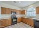 Kitchen with wood cabinets, black appliances, and tile floor at 4933 E Meadow Mist Ln, San Tan Valley, AZ 85140