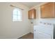 Laundry room with washer, dryer, and wooden cabinets at 4933 E Meadow Mist Ln, San Tan Valley, AZ 85140