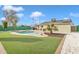 Spacious backyard oasis featuring a kidney-shaped pool and artificial turf at 557 S Visalia St, Mesa, AZ 85202