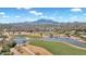 Aerial view of golf course and community with mountain backdrop at 6688 S Cartier Dr, Gilbert, AZ 85298