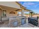 Outdoor kitchen with built-in grill, sink, and mini-fridge at 6688 S Cartier Dr, Gilbert, AZ 85298