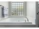 Relaxing bathroom with large soaking tub and block glass window at 6841 N 183Rd Ave, Waddell, AZ 85355