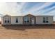 Tan and beige exterior of a manufactured home with a front door and several windows at 7710 S 350Th Ave, Tonopah, AZ 85354