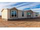 Manufactured home with light tan and brown exterior, multiple windows, and a front door at 7710 S 350Th Ave, Tonopah, AZ 85354