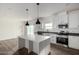 Bright kitchen with white cabinets, center island, stainless steel appliances, and dark countertops at 7710 S 350Th Ave, Tonopah, AZ 85354