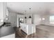 Spacious kitchen with white cabinets, an island, stainless steel appliances, and dark countertops at 7710 S 350Th Ave, Tonopah, AZ 85354