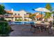 Community pool with ample seating and patio umbrella at 7800 E Lincoln Dr # 2053, Scottsdale, AZ 85250