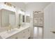 Elegant bathroom with double vanity, gold fixtures, and a view of another room at 7818 W Encinas Ln, Phoenix, AZ 85043