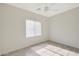 Simple bedroom with ceiling fan, wood-look floors and window at 7818 W Encinas Ln, Phoenix, AZ 85043