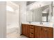 Bathroom with double sinks, wood cabinets, and a bathtub at 7915 W Wethersfield Rd, Peoria, AZ 85381