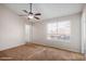 Spacious bedroom with carpeted floor, large window, and ceiling fan at 8039 N 48Th Ave, Glendale, AZ 85302