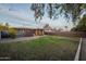 Spacious backyard features green lawn, gravel area, covered patio, and charming string lights for evening ambiance at 811 W Whitton Ave, Phoenix, AZ 85013