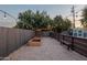 Fenced backyard with charming string lights, raised garden beds, and benches, creates a relaxing outdoor retreat at 811 W Whitton Ave, Phoenix, AZ 85013