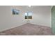 Bright bedroom featuring neutral carpet, white walls, and two large windows offering scenic outdoor views at 811 W Whitton Ave, Phoenix, AZ 85013