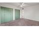 Bedroom with neutral carpet, white walls, and distinctive green closet doors with circular patterns at 811 W Whitton Ave, Phoenix, AZ 85013