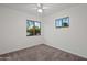 Bedroom with neutral carpet, white walls, and two windows providing natural light and outdoor views at 811 W Whitton Ave, Phoenix, AZ 85013