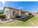 Inviting backyard includes a covered patio, vibrant lawn, and tasteful rock accents at 9144 W Sands Dr, Peoria, AZ 85383