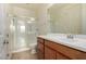 Bright bathroom featuring a glass-enclosed shower, single sink vanity, and tile flooring at 9144 W Sands Dr, Peoria, AZ 85383