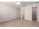 Neutral bedroom with tile flooring, ceiling fan, and closet with shelving at 9144 W Sands Dr, Peoria, AZ 85383