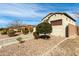 Tan stucco home with a brown garage door and desert landscaping under a blue sky at 9144 W Sands Dr, Peoria, AZ 85383