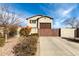 Charming stucco home with a wooden gate and desert landscaping under a bright blue sky at 9144 W Sands Dr, Peoria, AZ 85383