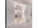 Bright foyer boasts neutral tile flooring, a modern light fixture, and a view into the powder room at 9144 W Sands Dr, Peoria, AZ 85383