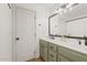 Bathroom with double vanity, green cabinets, and a large mirror at 9449 S 156Th Pl, Gilbert, AZ 85234