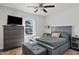 Spacious bedroom with gray platform bed, dresser, and large window at 9449 S 156Th Pl, Gilbert, AZ 85234