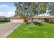 Single story home with attached garage and carport, mature shade tree, and well-maintained lawn at 9506 W Greenhurst Dr, Sun City, AZ 85351