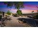 Peaceful backyard with a tree, gravel, and sunset at 9533 W Cedar Hill N Cir, Sun City, AZ 85351