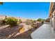 View of backyard pathway, stone wall, and citrus trees at 1000 Leisure World --, Mesa, AZ 85206