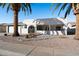 Single-story home with covered patio, desert landscaping, and two palm trees at 1000 Leisure World --, Mesa, AZ 85206