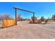 Long driveway leading to a rustic wooden gate and a ranch style home at 10137 N White Rd, Maricopa, AZ 85139