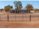 Ranch-style home exterior with trees and a metal fence at 10137 N White Rd, Maricopa, AZ 85139