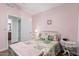 Light pink bedroom with white metal bed frame and ensuite bathroom at 10606 E Hercules Dr, Sun Lakes, AZ 85248