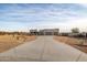 Long driveway leading to a modern house in a desert setting at 12093 W Blackhawk Rd, Casa Grande, AZ 85194