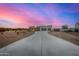 Beautiful desert home with a long driveway, at sunset at 12093 W Blackhawk Rd, Casa Grande, AZ 85194