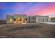 Modern stucco home with three-car garage at sunset at 12093 W Blackhawk Rd, Casa Grande, AZ 85194