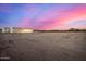 Desert lot with newly constructed home; sunset in background at 12093 W Blackhawk Rd, Casa Grande, AZ 85194