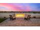 Cozy backyard fire pit with seating area at sunset at 12093 W Blackhawk Rd, Casa Grande, AZ 85194