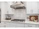 Stainless steel gas cooktop and range hood in kitchen at 12093 W Blackhawk Rd, Casa Grande, AZ 85194