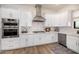 Modern white kitchen with stainless steel appliances and gas cooktop at 12093 W Blackhawk Rd, Casa Grande, AZ 85194