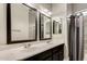 Bathroom with double sinks, dark vanity, and decorative mirrors at 13434 W Jacobson Dr, Litchfield Park, AZ 85340