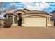 Tan house with a three-car garage and mature trees at 1358 E Jardin Dr, Casa Grande, AZ 85122