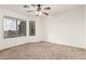 Bright bedroom with carpeted floors, ceiling fan, and large windows at 1503 N Quail Ln, Gilbert, AZ 85233