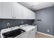 Laundry room with washer, dryer, and white cabinets at 1503 N Quail Ln, Gilbert, AZ 85233