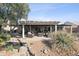 Serene backyard with covered patio, pond, and desert landscaping at 15045 W Mulberry Dr, Goodyear, AZ 85395